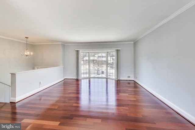 spare room with an inviting chandelier, crown molding, and dark wood-type flooring