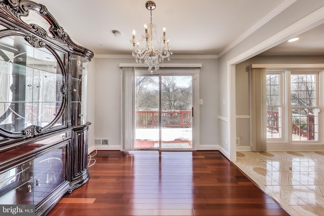 doorway to outside with ornamental molding, dark hardwood / wood-style floors, and a notable chandelier