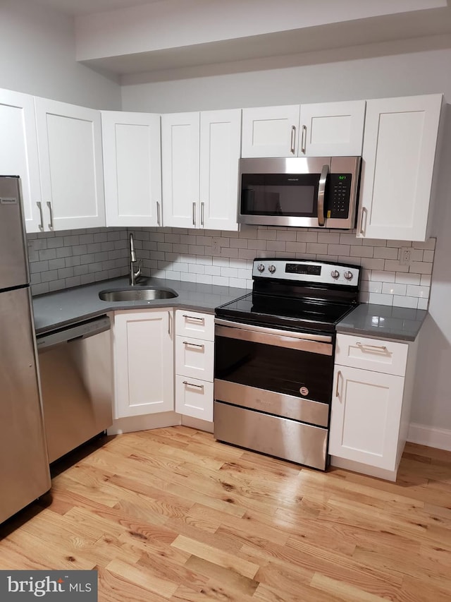 kitchen featuring sink, white cabinetry, appliances with stainless steel finishes, and tasteful backsplash