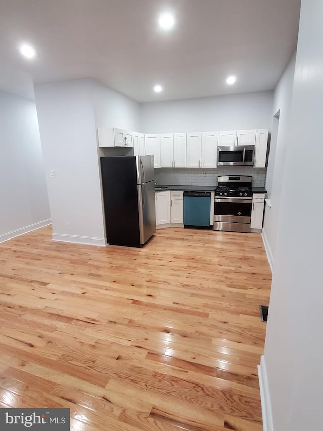 kitchen featuring light wood-type flooring, white cabinetry, tasteful backsplash, and stainless steel appliances