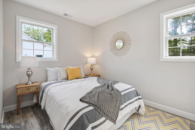 bedroom featuring hardwood / wood-style floors and multiple windows