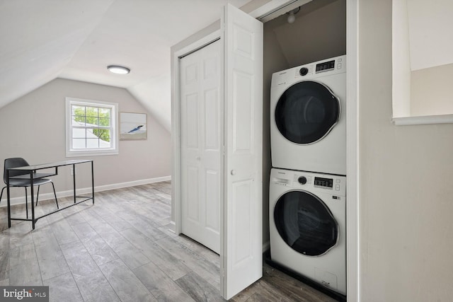 clothes washing area with stacked washer / dryer and hardwood / wood-style floors