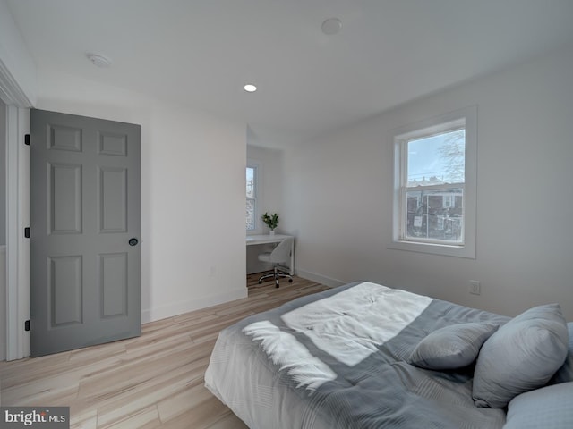 bedroom featuring multiple windows and light hardwood / wood-style floors