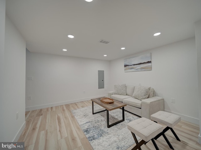 living room with electric panel and light wood-type flooring