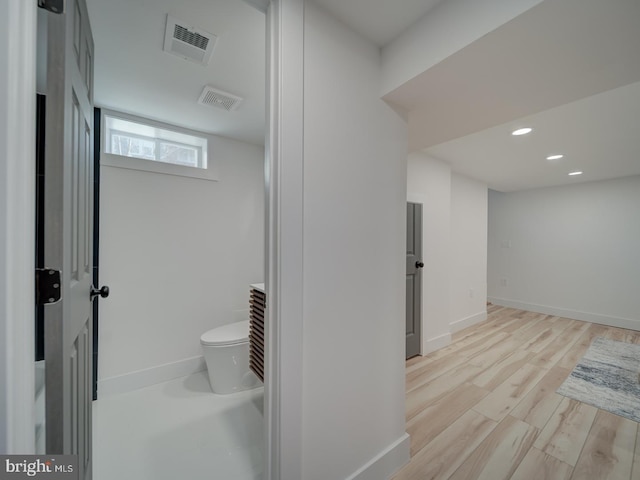 bathroom with hardwood / wood-style flooring and toilet