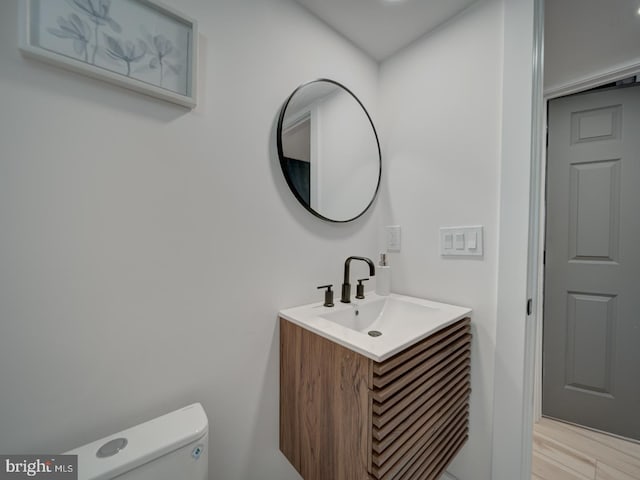 bathroom featuring vanity, toilet, and hardwood / wood-style floors