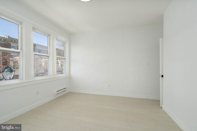 unfurnished room with baseboard heating