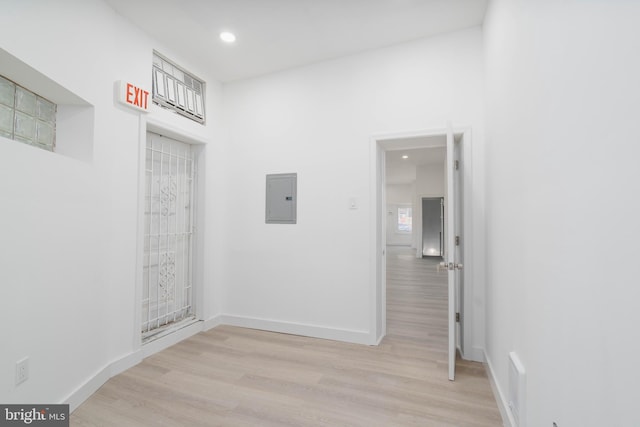 hallway with electric panel and light hardwood / wood-style floors