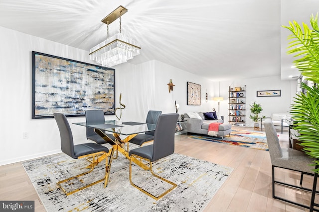 dining area with a notable chandelier and light wood-type flooring