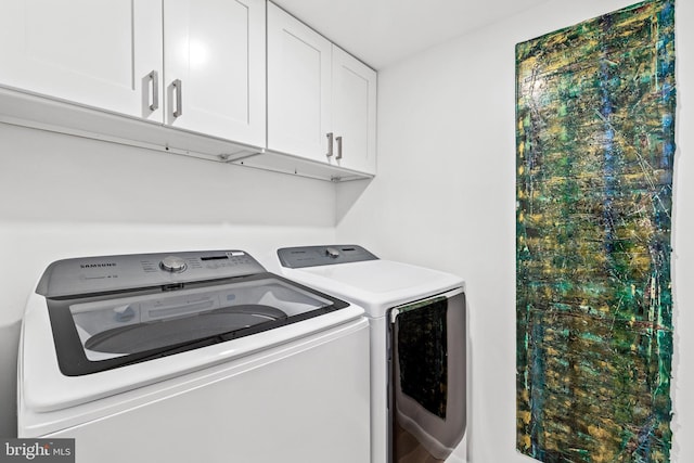 clothes washing area featuring cabinets and independent washer and dryer