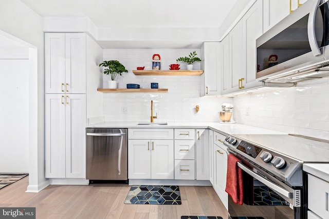 kitchen featuring tasteful backsplash, appliances with stainless steel finishes, sink, and white cabinets