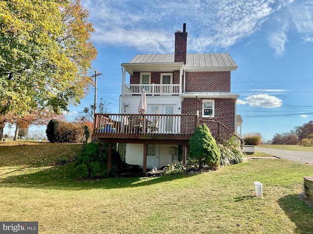 back of property featuring a wooden deck and a yard