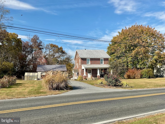 view of front of home featuring an outbuilding and a front lawn