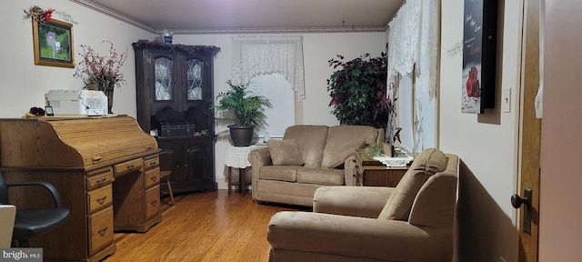 living area with light hardwood / wood-style flooring and ornamental molding