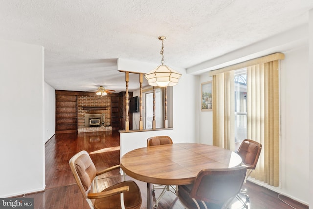 dining area featuring ceiling fan, a textured ceiling, and dark hardwood / wood-style flooring