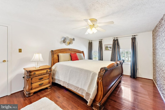 bedroom featuring a textured ceiling, ceiling fan, and dark hardwood / wood-style flooring