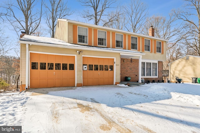 view of front facade featuring a garage, a chimney, and brick siding