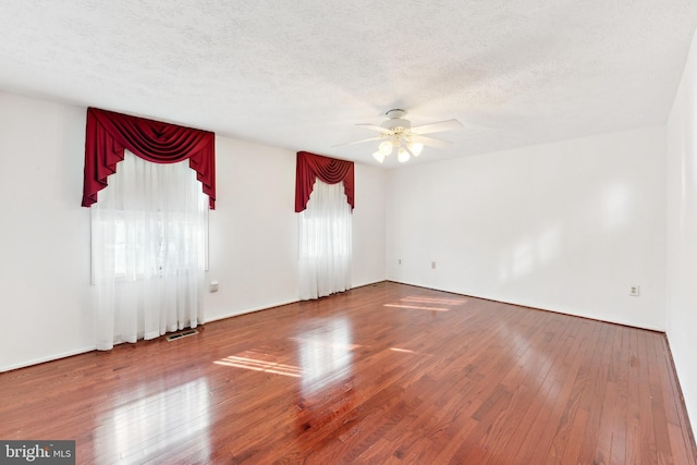 spare room with ceiling fan, hardwood / wood-style floors, and a textured ceiling