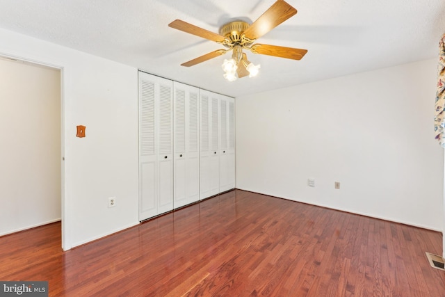 unfurnished bedroom featuring ceiling fan, hardwood / wood-style floors, and a closet