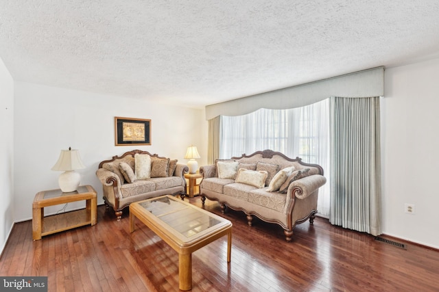 living room with wood-type flooring and a textured ceiling