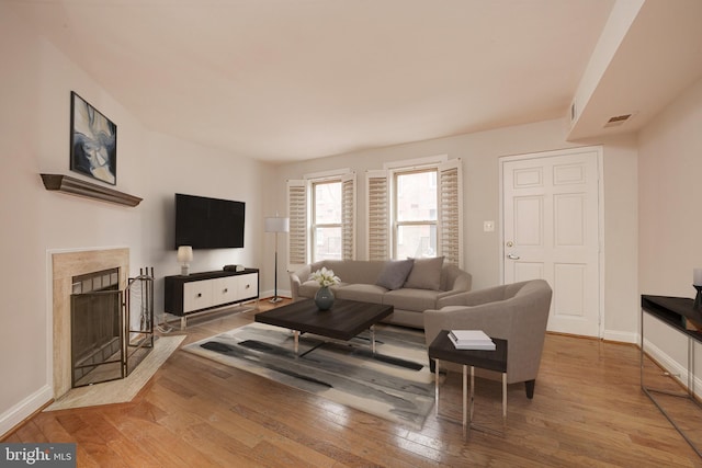 living room featuring hardwood / wood-style floors and a high end fireplace