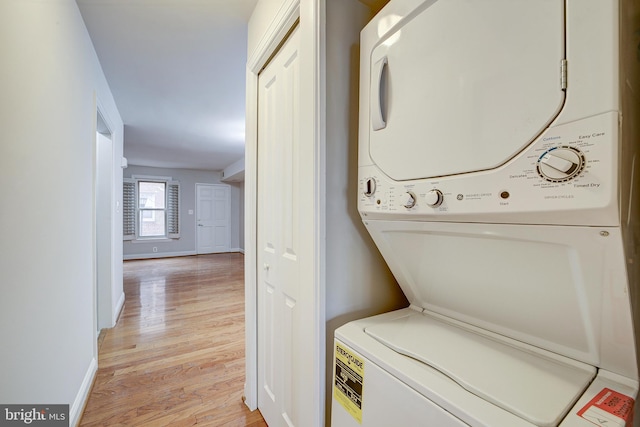 laundry room featuring stacked washing maching and dryer and light wood-type flooring