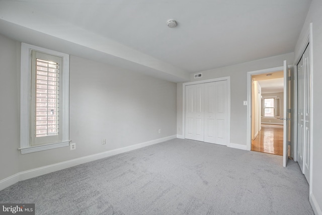 unfurnished bedroom featuring light carpet