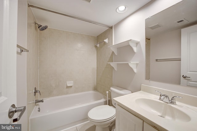 full bathroom featuring vanity, tiled shower / bath combo, and toilet