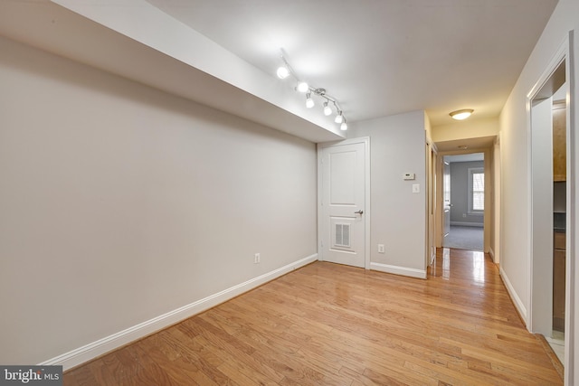 spare room with track lighting and light hardwood / wood-style floors