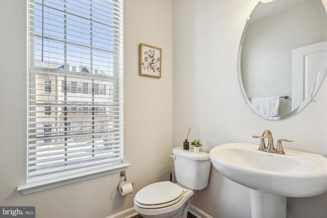 bathroom featuring a healthy amount of sunlight, toilet, and sink