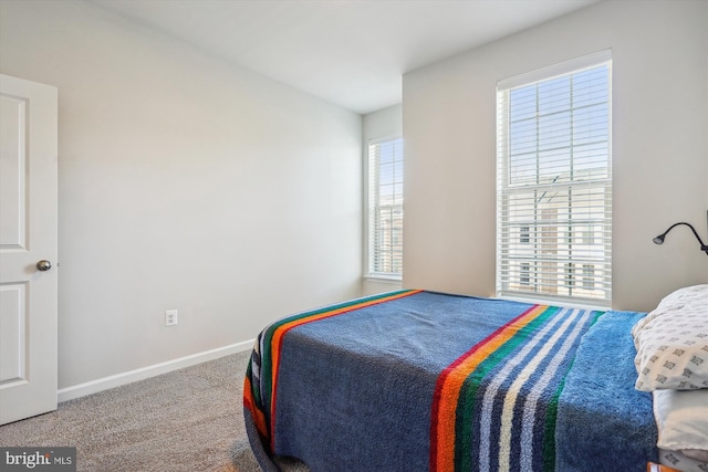 carpeted bedroom featuring multiple windows