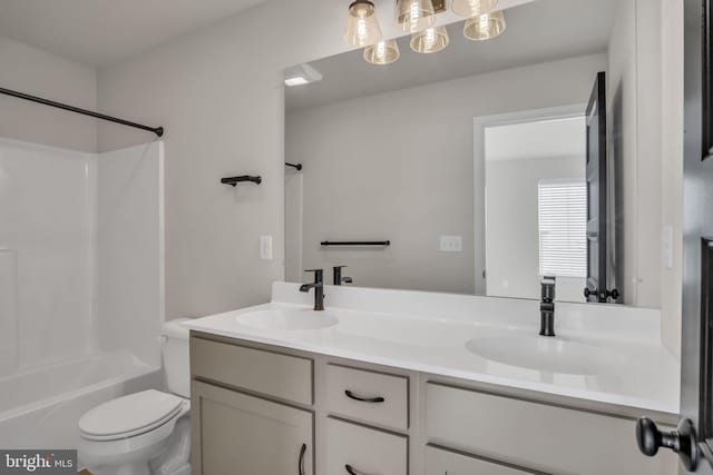 full bathroom with toilet, vanity, and  shower combination