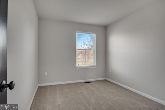 spare room featuring light colored carpet