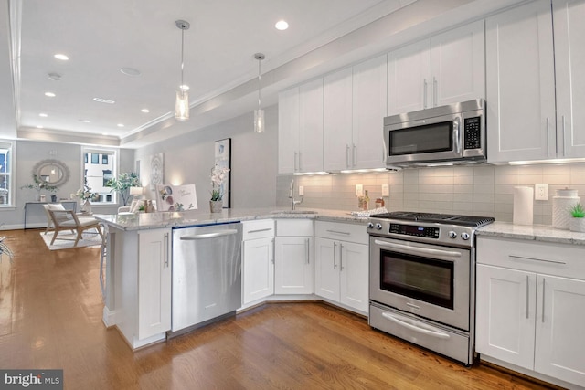 kitchen with pendant lighting, white cabinetry, appliances with stainless steel finishes, and sink