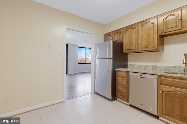 kitchen with sink, stainless steel appliances, and light stone countertops