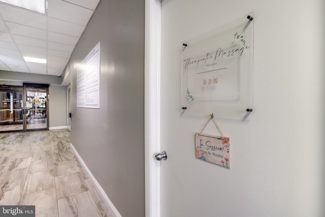 hallway featuring hardwood / wood-style flooring and a paneled ceiling