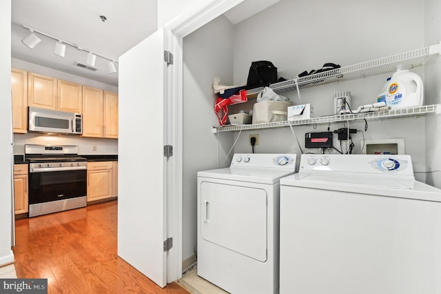 laundry room with separate washer and dryer and light wood-type flooring