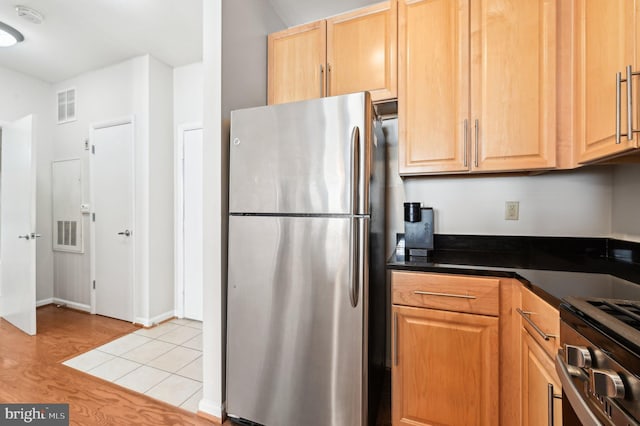 kitchen with appliances with stainless steel finishes, light brown cabinets, and light hardwood / wood-style flooring