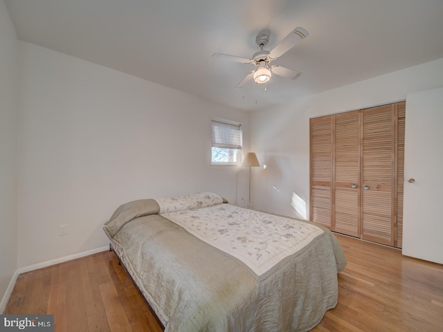 bedroom featuring ceiling fan, light hardwood / wood-style flooring, and a closet