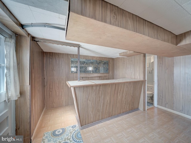 bar featuring wood walls and light parquet floors