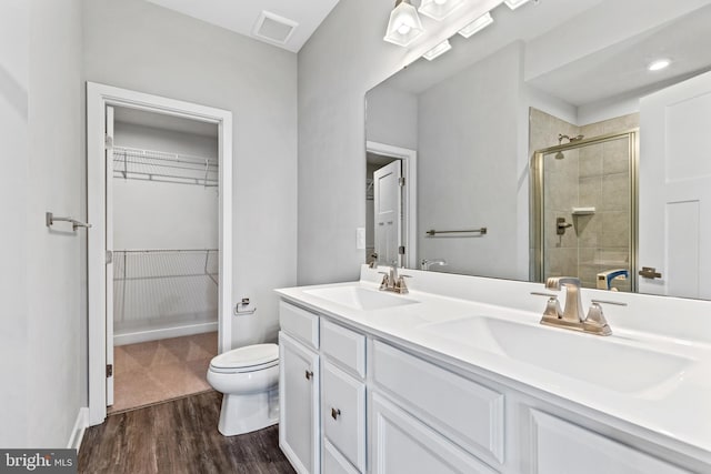 bathroom featuring walk in shower, wood-type flooring, toilet, and vanity