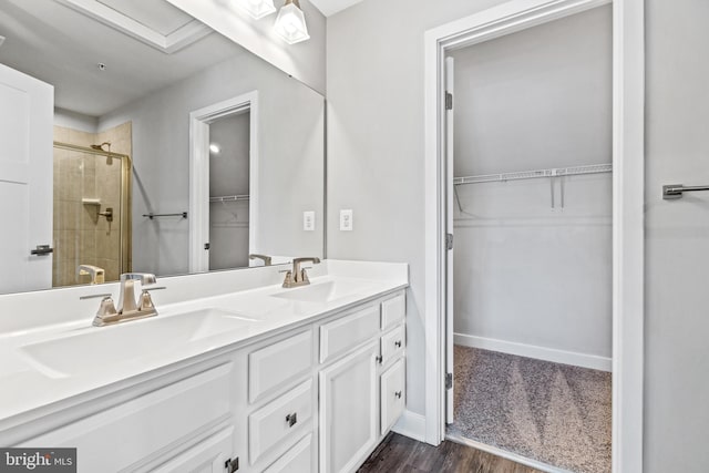 bathroom featuring vanity, wood-type flooring, and walk in shower