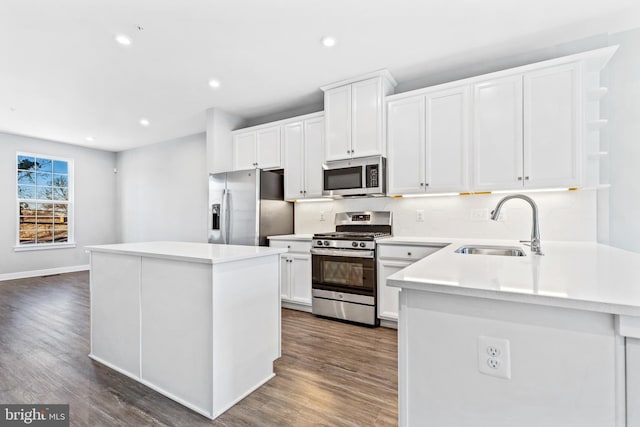 kitchen featuring a kitchen island, appliances with stainless steel finishes, dark hardwood / wood-style floors, white cabinetry, and sink