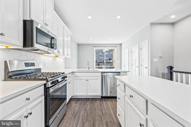 kitchen featuring appliances with stainless steel finishes, dark hardwood / wood-style floors, sink, and white cabinets