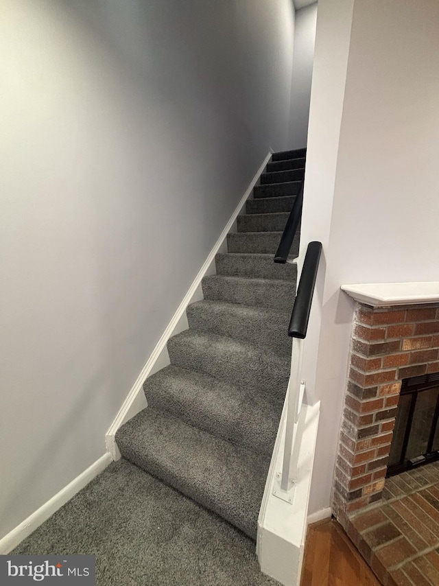 stairway with a brick fireplace