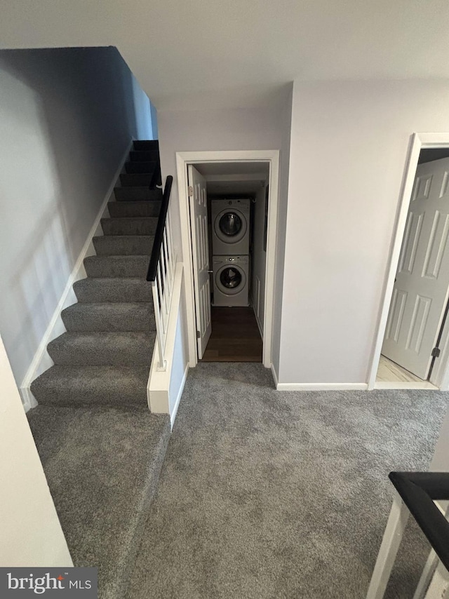 staircase featuring carpet and stacked washer / drying machine