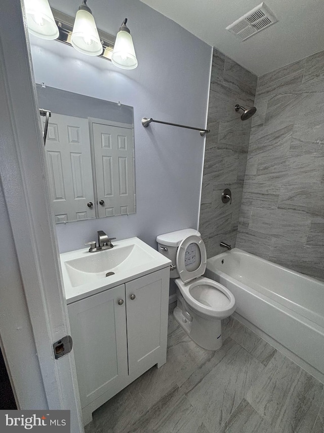 full bathroom with vanity, toilet, and tiled shower / bath combo