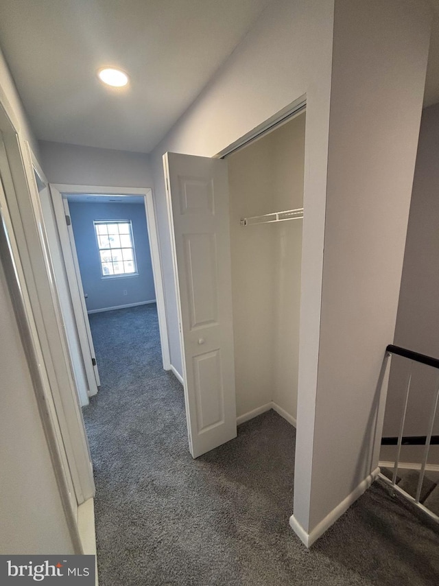 hallway featuring dark colored carpet