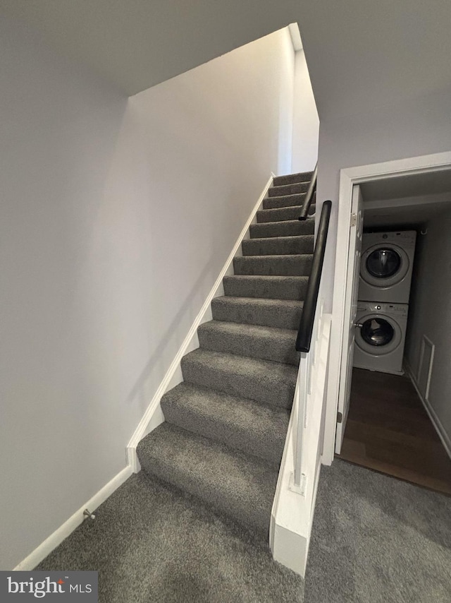 staircase with carpet and stacked washing maching and dryer