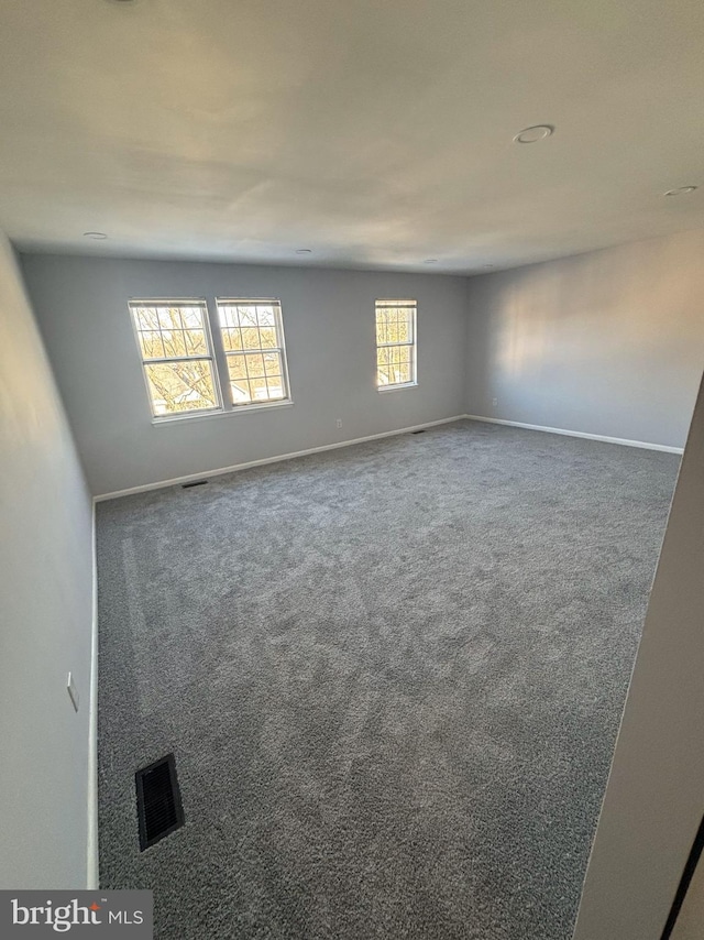 spare room featuring dark colored carpet